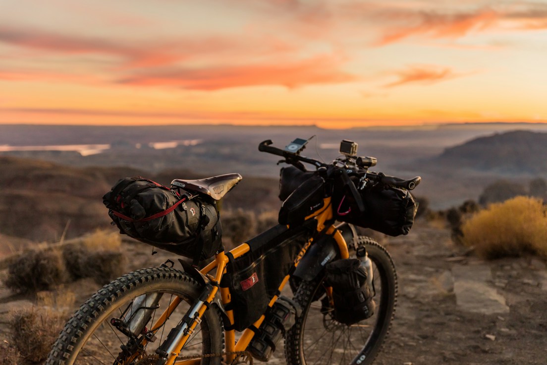 A bicycle carrying bikepacking equipment at sunset; outdoor equipment inspiration